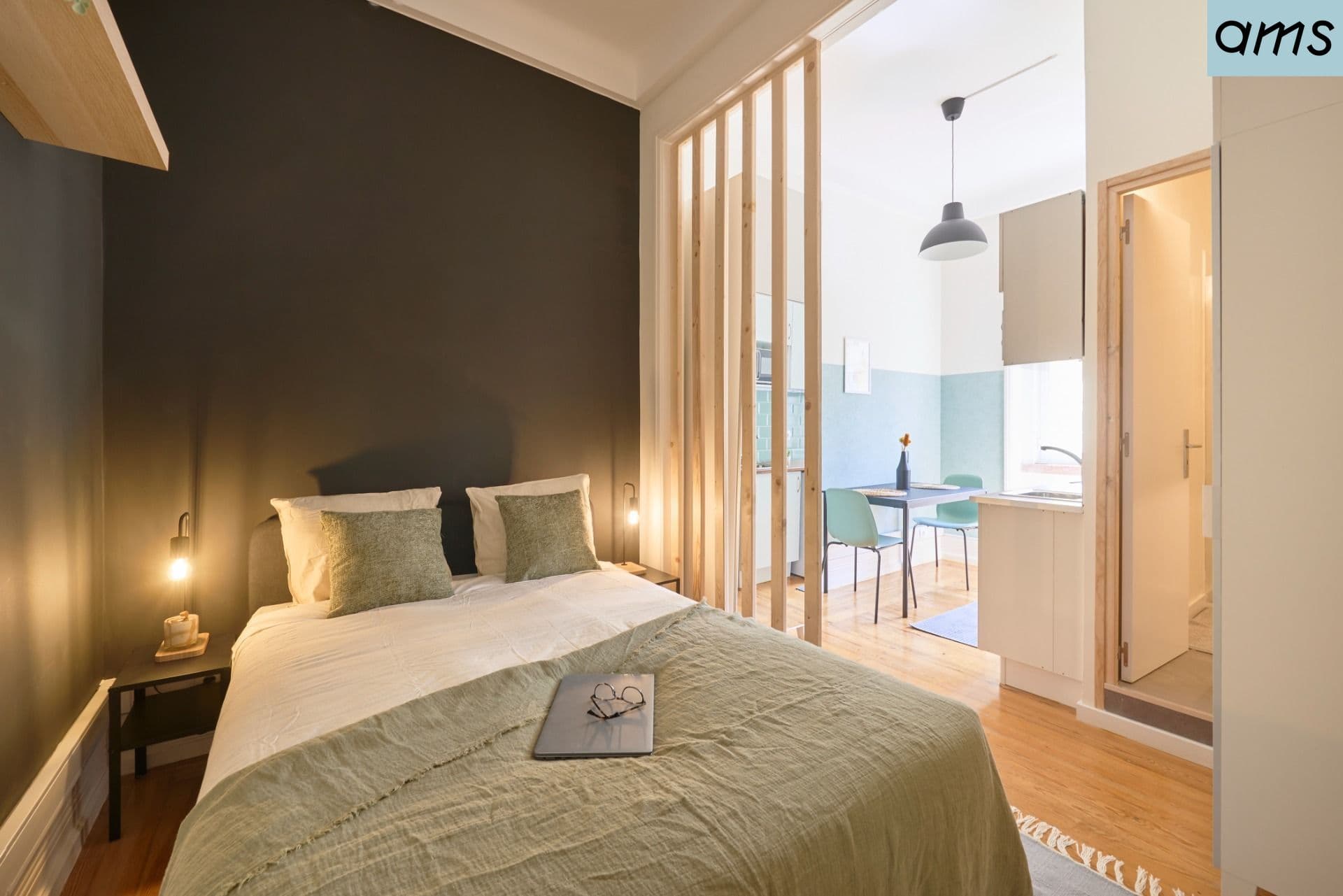 The bedroom and kitchen of a furnished AMS apartment in Lisbon